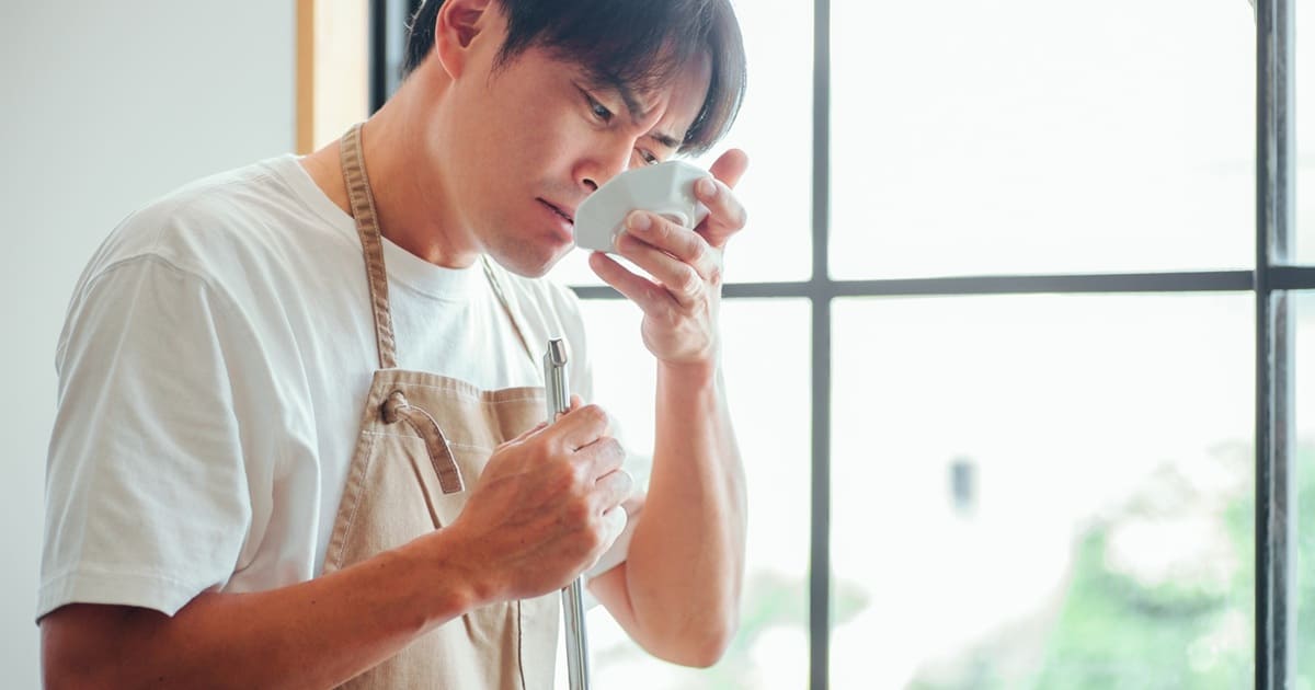 料理の味見をする男性