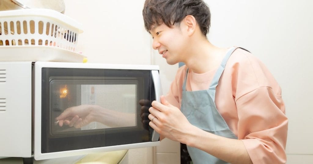 電子レンジの扉を開ける男性
